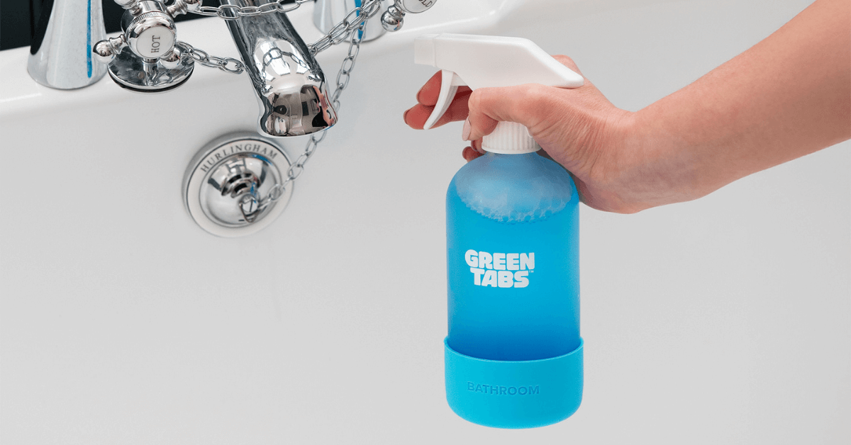eco friendly bathroom cleaner being held in hand over bath