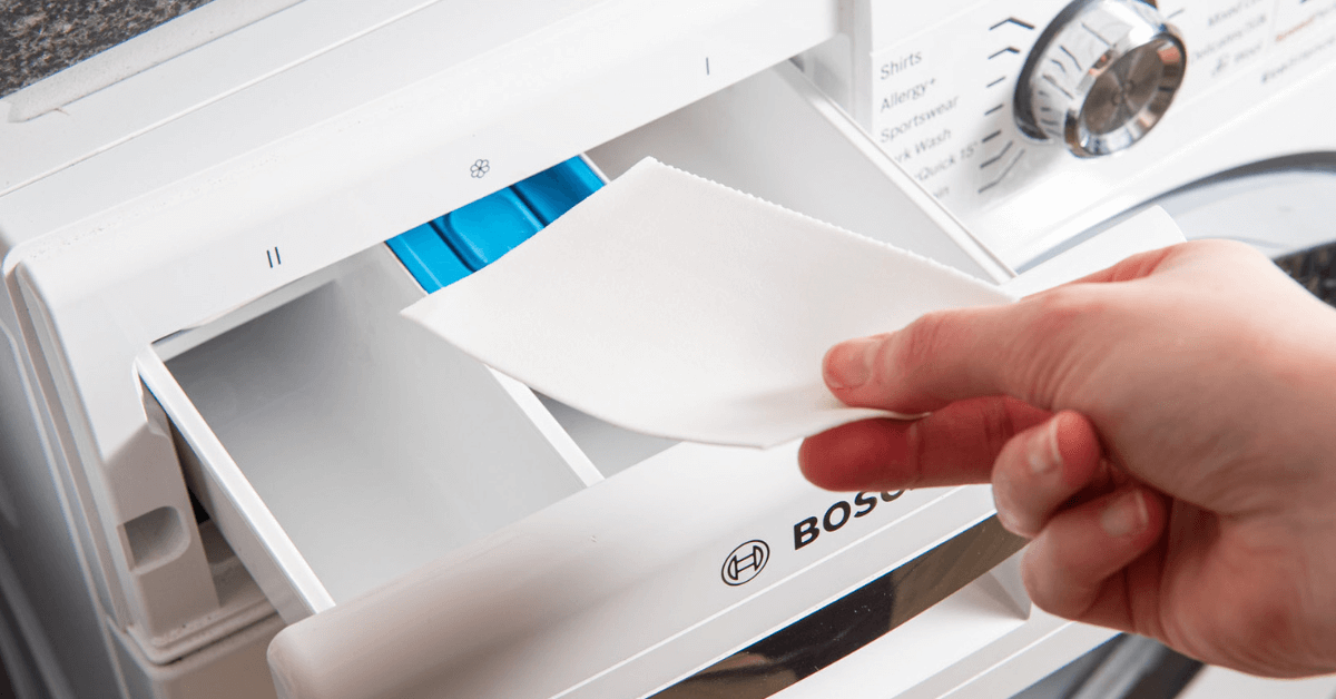 laundry detergent sheet being put into washing machine