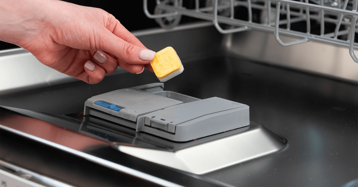eco dishwasher greentab being placed into dishwasher to help clean dishwasher