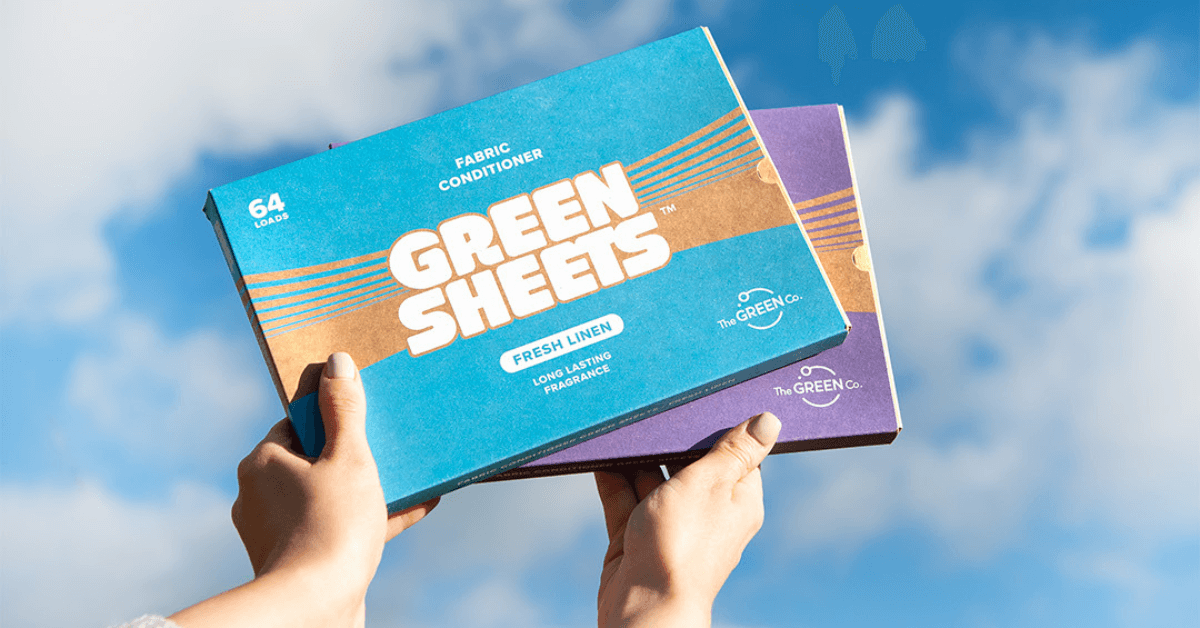 fabric conditioner greensheets in fresh linen and lavender being held by hands against sky backdrop