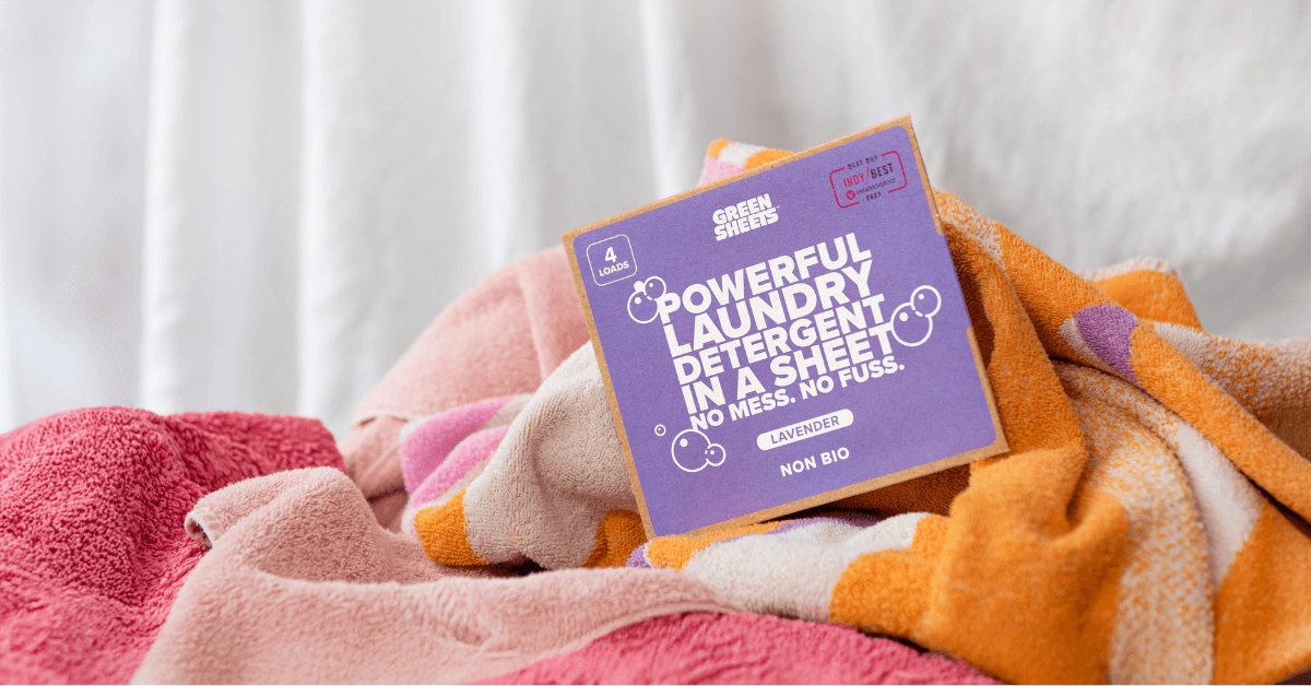greensheets laundry detergent sample pack sitting on towels and clothing for hand washing clothes while travelling