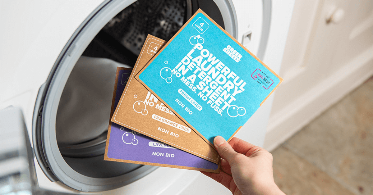 laundry sheets samples from the green co held in front of washing machine