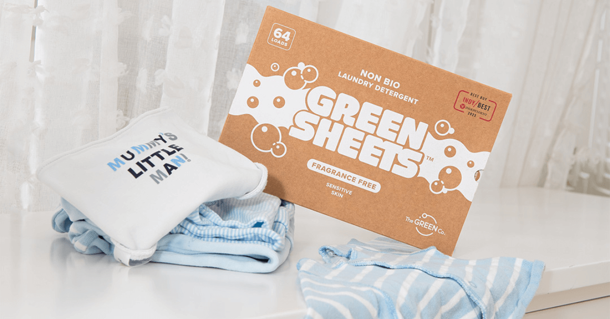 natural laundry detergent greensheets™ compostable packet sitting by pile of baby clothing