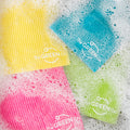 Green Cellulose Dish Cloth, Pink Cellulose Dish Cloth, Blue Cellulose Dish Cloth and Yellow Cellulose Dish Cloth in bubbly water