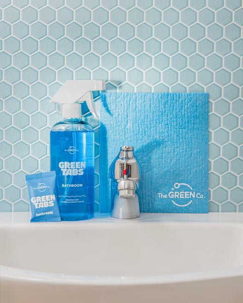 Blue Bathroom Cleaner GreenTab in Forever Bottle, Bathroom Cleaner GreenTab in packaging and Blue Cellulose dish cloth sitting on Bathroom sink next the tap