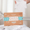 The Green Company fresh linen non bio laundry detergent 128 load pack resting on a white towel, next to some white t shirts being folded after a wash