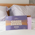 Purple Lavender Fabric conditioner GreenSheets being half open sitting on a bed