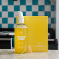 yellow kitchen degreaser GreenTab in forever bottle with yellow GreenTab and yellow cellulose dish cloth, sitting on kitchen worktop in front of blue and white kitchen tiles