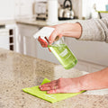 Multipurpose GreenTab in forever bottle being sprayed onto kitchen worktop, cellulose dish cloth being used to clean