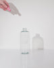 Gif video that shows a hand dropping in a Glass Cleaner GreenTab into a forever bottle infront of white backdrop, Gif showcasing how GreenTab dissolves